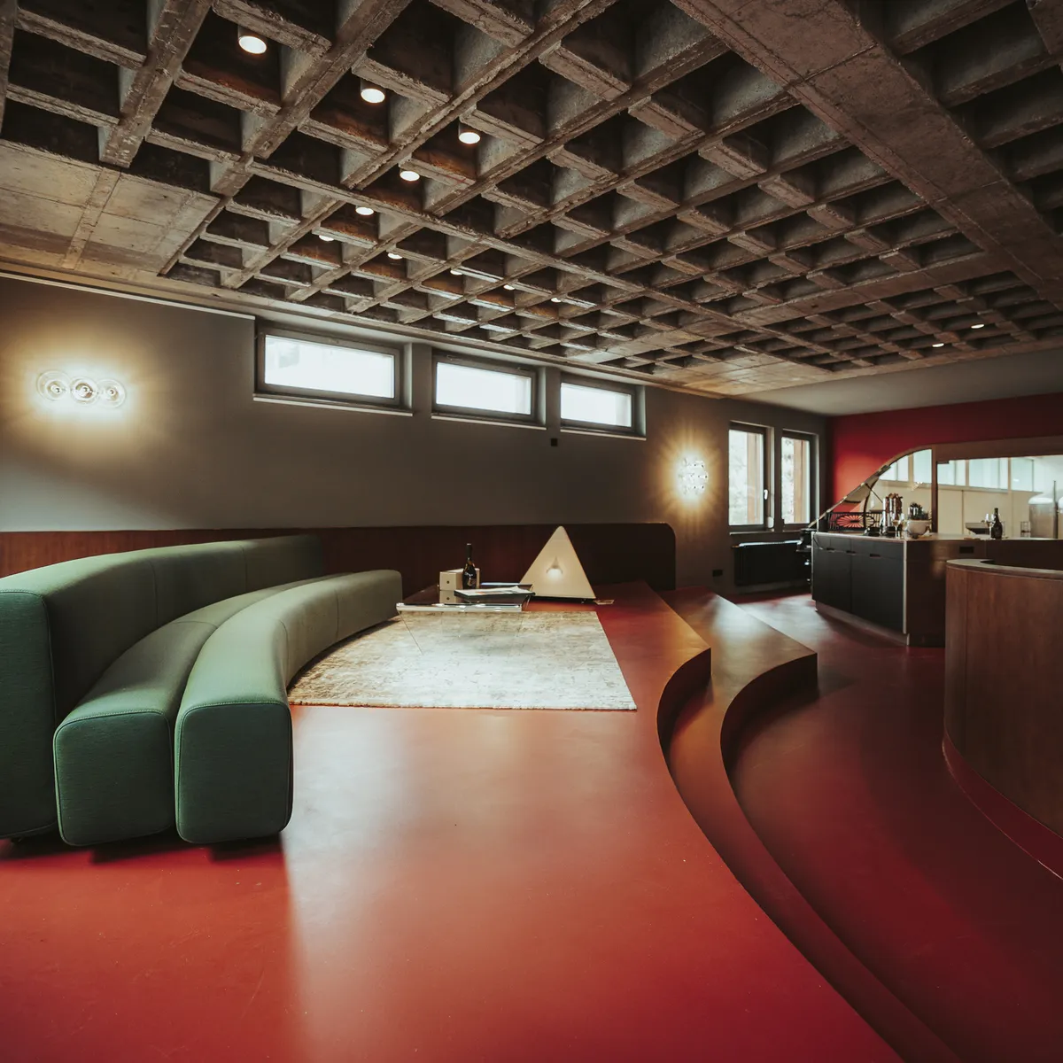 Lounge mit grünem Sofa und rotem Boden in der Sektmanufaktur