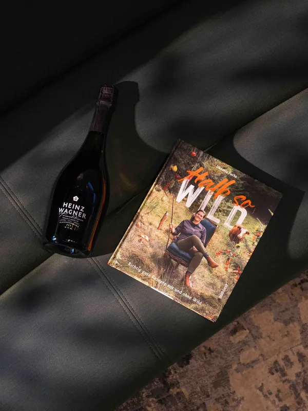 Kochbuch von Viktoria Fuchs neben einer Flasche Heinz Wagner Sekt