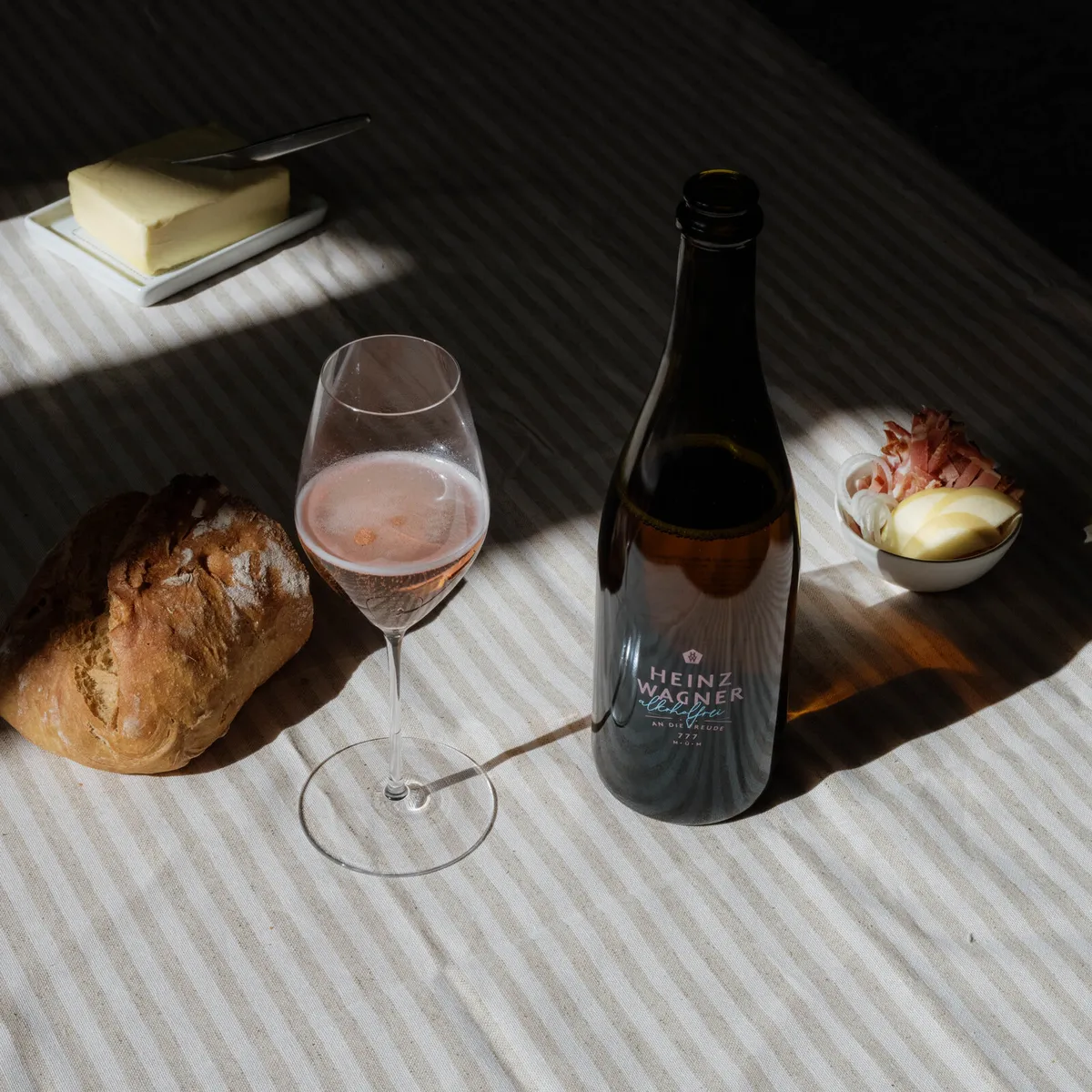 Flasche Heinz Wagner Alkoholfrei mit gefülltem Glas, Brot und Butter auf einem Tisch
