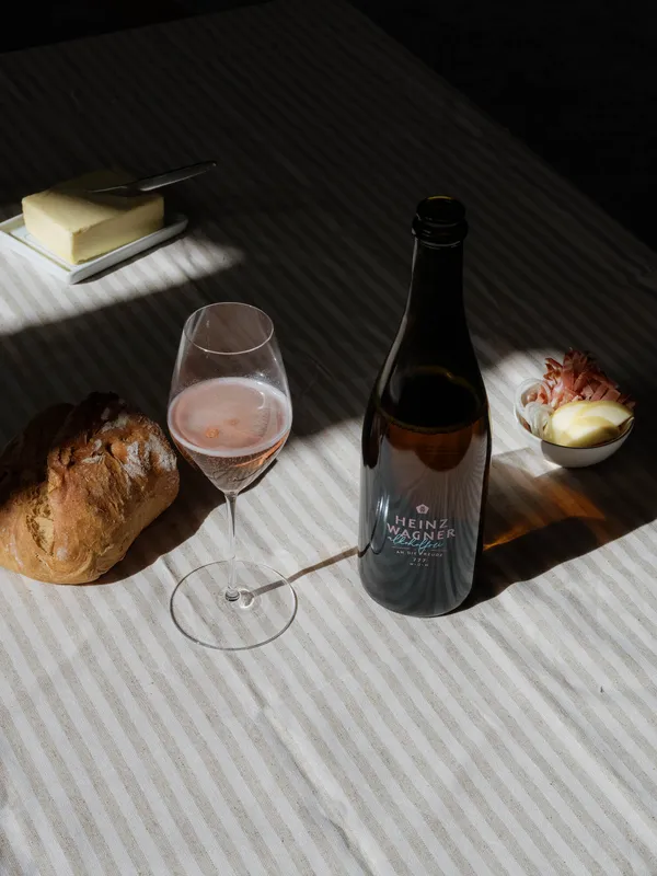 Flasche Heinz Wagner Alkoholfrei mit gefülltem Glas, Brot und Butter auf einem Tisch