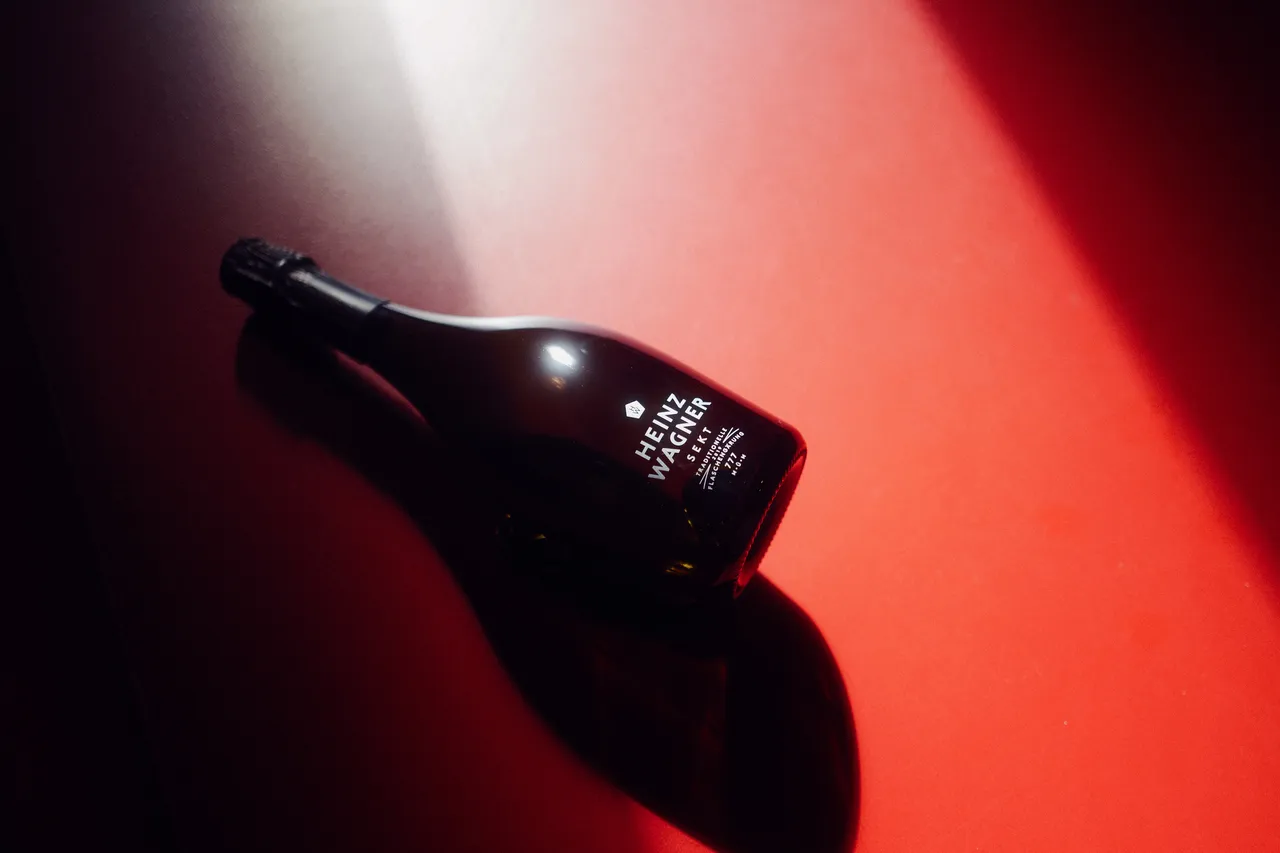 Liegende Heinz-Wagner-Sektflasche in rotem Licht